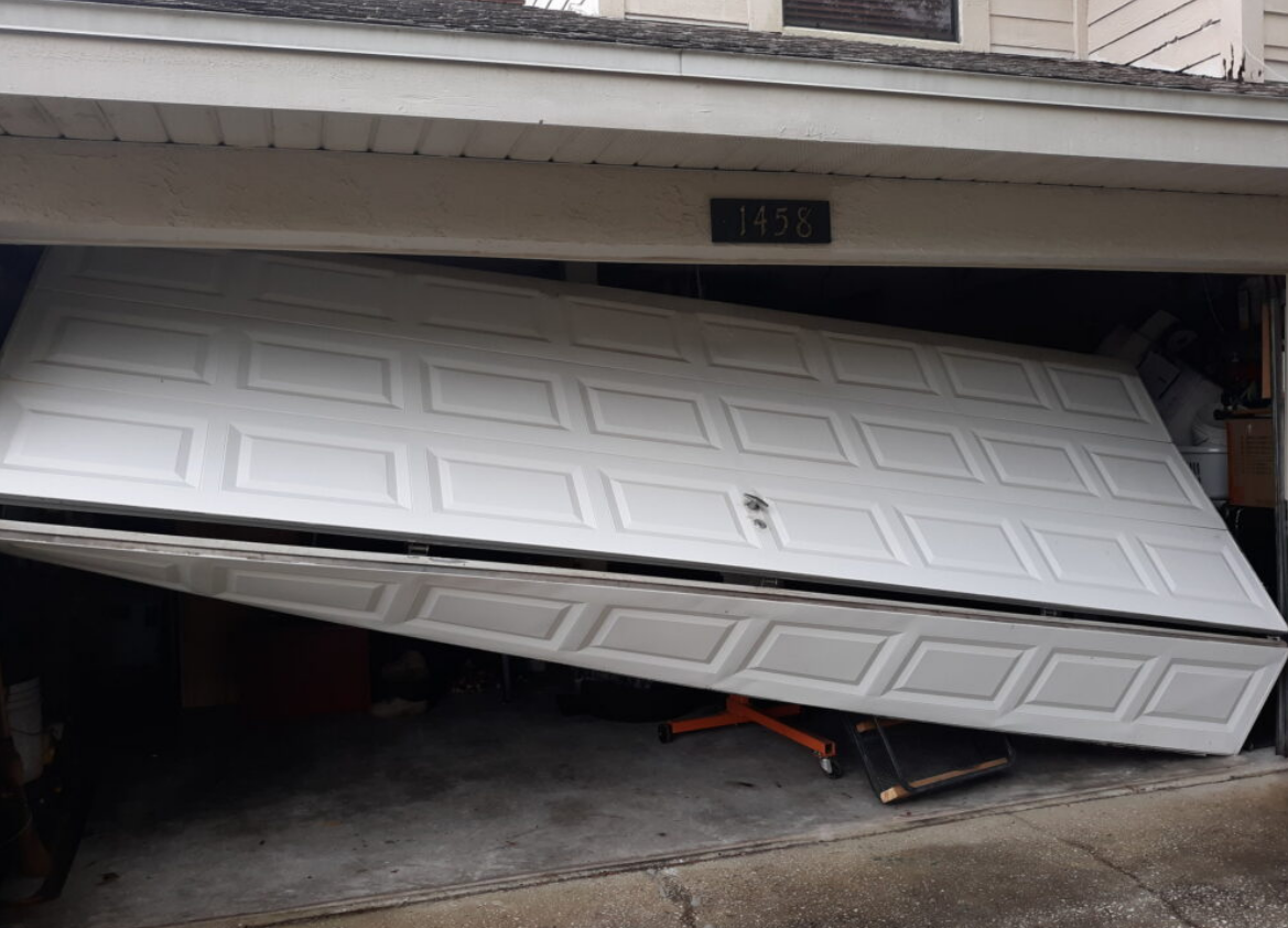 a technician performing garage door repair in Bradenton, showcasing the process of fixing a residential garage door spring with tools visible in the background.